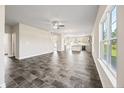 A spacious living room with tile floors, a ceiling fan, and bright natural light through the windows at 29 Red Bird Dr, Cameron, NC 28326