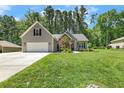 Traditional style home featuring a well-manicured lawn, attached garage, stone accents, and gray siding at 787 Cashmere Ct, Sanford, NC 27332