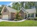 Charming exterior of a home featuring stone accents, gray siding, a landscaped yard, and an attached garage at 787 Cashmere Ct, Sanford, NC 27332