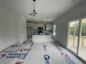 Bright kitchen features an island, modern lighting, stainless appliances, and a sliding door to the outside at 138 Travelers Way, Lillington, NC 27546