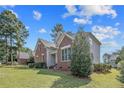 View of the side of a two-story home with brick and vinyl siding, green lawn and mature landscaping at 55 Blue Pine Dr, Spring Lake, NC 28390