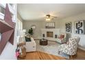 Bright living room featuring hardwood floors, a ceiling fan, and a brick fireplace at 5824 Adcock Rd, Holly Springs, NC 27540