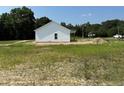 Single story construction with white siding, a black roof, and a covered patio at 5964 Godwin Lake Rd, Benson, NC 27504
