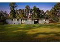 Beautiful single story home with a well-manicured lawn and a long driveway leading to a covered parking area at 602 Canterbury Rd, Sanford, NC 27330