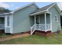 A view of the side of the home, showing the light blue siding and brick foundation at 108 Shady Meadows Ln, Clayton, NC 27520