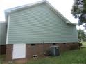 A view of the side exterior of a home with light blue siding and a brick foundation at 108 Shady Meadows Ln, Clayton, NC 27520