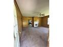 Cozy living room featuring wood paneling, carpet flooring, a ceiling fan, and a fireplace at 410 W K St, Erwin, NC 28339