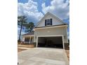 Attached two-car garage with extended driveway and exterior lighting in a newly constructed residential home at 46 Poplar Dr, Spring Lake, NC 28390