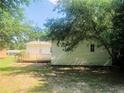 View of the home with a wood deck overlooking the backyard, shaded by mature trees at 644 Moores Chapel Rd, Lillington, NC 27546
