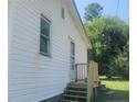 Side view of home with white siding and a newly installed wood staircase leading to the entrance at 644 Moores Chapel Rd, Lillington, NC 27546