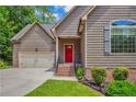 Inviting home exterior with a red front door, attached garage, and well-manicured landscaping at 125 Lakeforest Trl, Sanford, NC