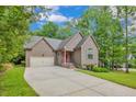 Charming single-Gathering home with an attached garage, concrete driveway, and well-maintained lawn at 125 Lakeforest Trl, Sanford, NC
