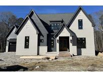 Striking two-story new construction home with gray brick and complementary trim details under a clear blue sky at 3812 Peaceful Creek Trl, Zebulon, NC 27597