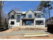 Exterior framing of a modern two-story home, featuring a combination of siding, stone accents, and large windows at 508 Northwood Dr, Raleigh, NC 27609