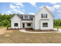 Stunning white farmhouse-style home with black accents, lush landscaping, and a beautiful curved walkway at 7327 Shawan Rd, Wendell, NC 27591