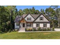 Charming home featuring stone accents, a covered porch, and a beautifully landscaped front yard at 143 Hook Dr # 23, Fuquay Varina, NC 27526