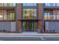 Modern building entrance with glass doors and wood accents, complemented by manicured landscaping at 600 N Roxboro St # 43, Durham, NC 27701
