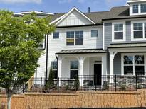 Charming new construction two-story home featuring black wrought iron fence, neutral paint colors, and manicured landscaping at 492 Traditions Grande Blvd # 26, Wake Forest, NC 27587