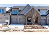 Charming townhome featuring a brick facade, neutral siding, a two-car garage, and professional landscaping at 804 Ambercrest Place, Durham, NC 27705