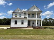 Charming two-story home featuring a covered front porch, white siding and a well-manicured lawn at 123 Sage Ln # 010, Four Oaks, NC 27524