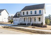 Two-story white house with gray roof, front porch, and two-car garage at 6063 Scalybark Road, Durham, NC 27712