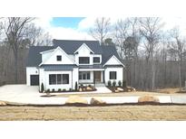 Beautiful two-story home boasting a modern exterior, complemented by professionally landscaped front yard and a two car garage at 122 W Beech Slope Ct, Chapel Hill, NC 27517