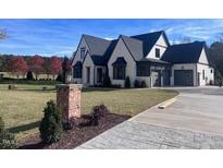Beautiful two-story home with landscaped yard, elegant dark trim, and driveway at 43 Laurel Knoll Dr, Pittsboro, NC 27312