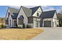 Stunning two-story home with a modern design, gray roof, white painted brick, and three-car garage at 43 Laurel Knoll Dr, Pittsboro, NC 27312