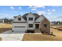 Beautiful new construction features a stone and white accent exterior, large garage and well manicured lawn at 125 Cotton Fields Ln # 26, Fuquay Varina, NC 27526