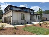 Beautiful home with stone and siding details, an attached garage, and a professionally landscaped front yard at 67 Quail Pt, Pittsboro, NC 27312