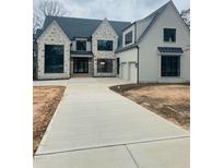 Stunning new two-story home with stone and painted brick, a paved driveway, and an attached two-car garage at 2227 Wheeler Rd, Raleigh, NC 27607