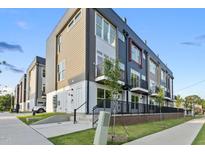 Modern townhome with neutral siding, balcony, sidewalk and manicured lawn at 2 Seawell Ave # 101, Raleigh, NC 27601