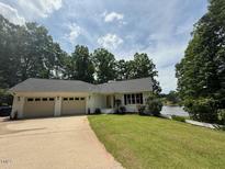 Charming one-story home boasts a lush lawn, lakeside setting, and convenient two-car garage at 3309 Westcott Cir, Sanford, NC 27330