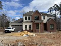 New construction, two-story home featuring brick and white siding, a two car garage, and large windows at 2633 Trifle Ln, Wake Forest, NC 27587