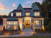 Stunning two-story home featuring brick and stone facade with an inviting arched entryway and professionally landscaped yard at 1621 Legacy Ridge Ln, Wake Forest, NC 27587