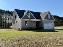 Two-story house with gray siding, a two-car garage, and a landscaped lawn at 106 Viola Ln, Franklinton, NC 27525