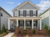 Charming two-story home with a covered front porch, white columns, and landscaped yard at 1505 Patchings Ln, Knightdale, NC 27545