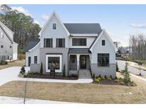 Charming two-story home with light blue siding, black trim, and a manicured front lawn at 9400 Rawson Ave, Raleigh, NC 27613