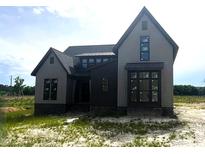 New two-story home with gray siding, black accents, and large windows under a bright, sunny sky at 4905 Hidden Pasture Way, Zebulon, NC 27597