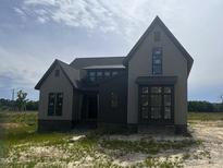 New construction home featuring board and batten siding, black windows, and a stone foundation at 4905 Hidden Pasture Way, Zebulon, NC 27597