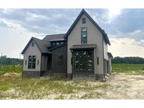 Beautiful two-story home with stone accents and gray siding, offering modern curb appeal and a welcoming facade at 4905 Hidden Pasture Way, Zebulon, NC 27597