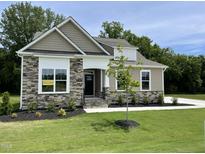 Beautiful single-story home with stone accents, manicured lawn, and a welcoming entrance at 69 Browning Mill Dr, Wendell, NC 27591