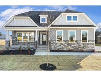 Two-story house with gray siding, stone accents, and a front porch at 55 Browning Mill Dr, Wendell, NC 27591