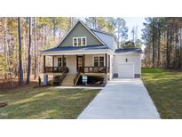 Charming two-story home with a welcoming front porch and well-manicured lawn at 158 Nakoma Dr, Louisburg, NC 27549