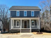 Two-story gray house with white trim, a front porch, and a nicely landscaped yard at 1010 Whitehall Cir, Durham, NC 27713