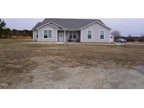 Ranch style home with gray siding, attached garage, and a spacious yard at 1850 Gillburg Road, Henderson, NC 27537