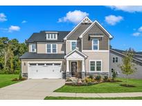 Charming two-story home with a manicured lawn, attached two-car garage, and covered front porch at 9113 Dupree Meadow Dr # 41, Angier, NC 27501