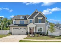 Charming two-story home with a manicured lawn, stone accents, and an attached two-car garage at 9113 Dupree Meadow Dr # 41, Angier, NC 27501