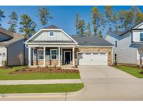 Charming single-story home featuring stone accents, a two-car garage, manicured lawn, and inviting front porch at 720 Heathered Farm Way, Apex, NC 27523