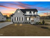 Beautiful two-story home showcasing elegant architectural details and a well-manicured lawn at sunset at 110 Summerlin Dr, Clayton, NC 27527